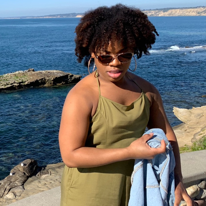 Michelle in her 20s, standing by the ocean